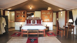 A spacious bedroom with a large bed, a wooden chair, a desk, and a mirror. - Tembo By Jackson  (Maasai Mara)