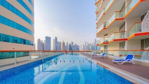 A swimming pool with a city skyline in the background. - Studio with Canal Views by Bespoke  (Dubai)