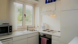 Une cuisine moderne équipée d’un four à micro-ondes, d’un évier, d’une cuisinière et de placards.