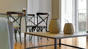 Un coin repas avec une table en verre, des chaises en métal et deux vases en osier posés sur la table.