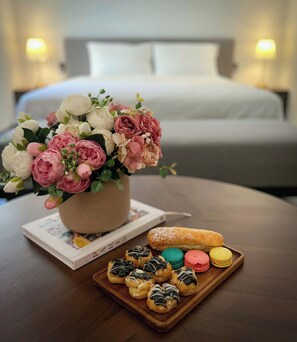 A bouquet of flowers on a table with pastries and a book.