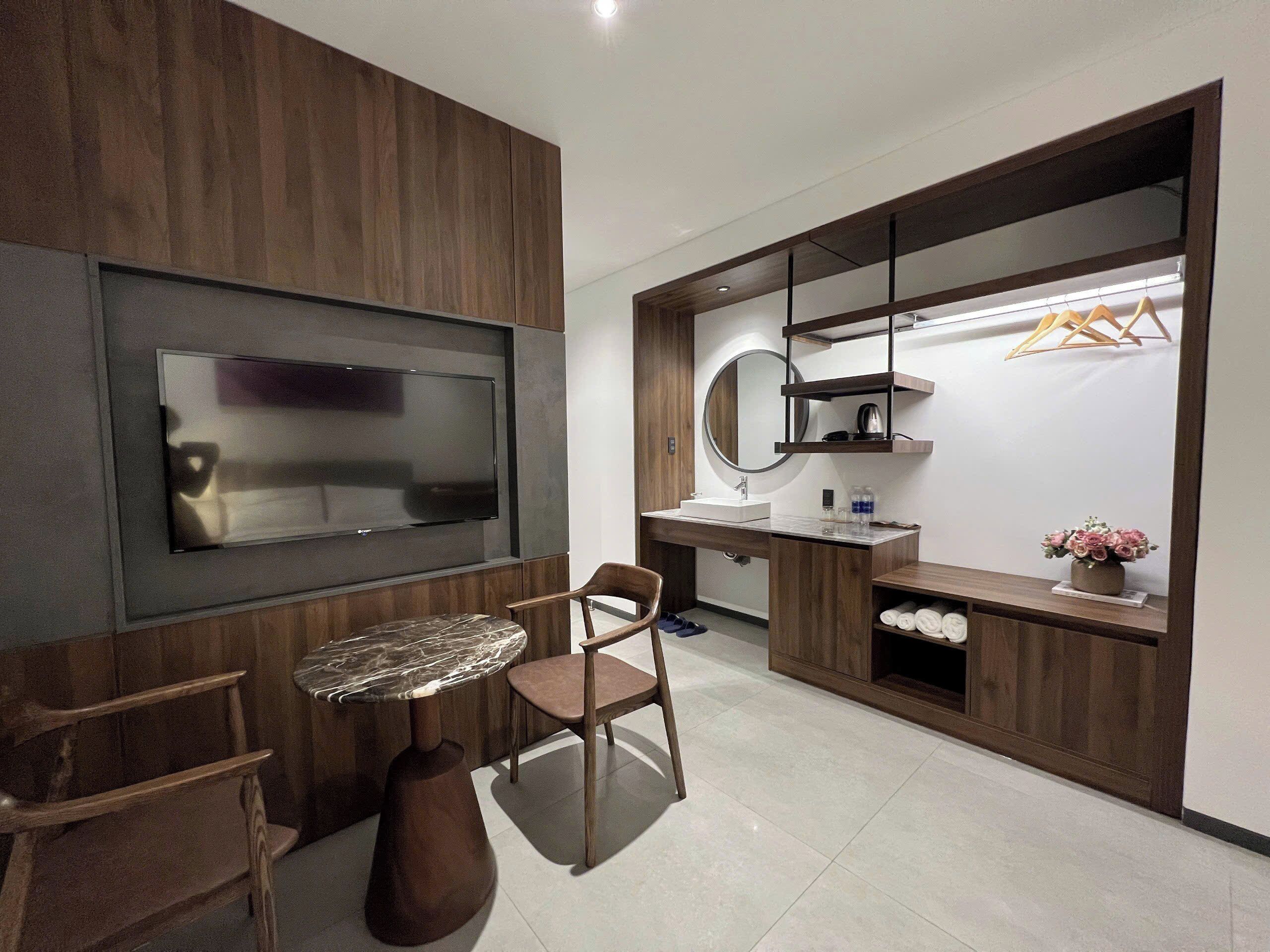 A modern bathroom with a large mirror, a sink, and a vanity with shelves.