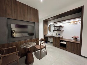 A modern bathroom with a large mirror, a sink, and a vanity with shelves.