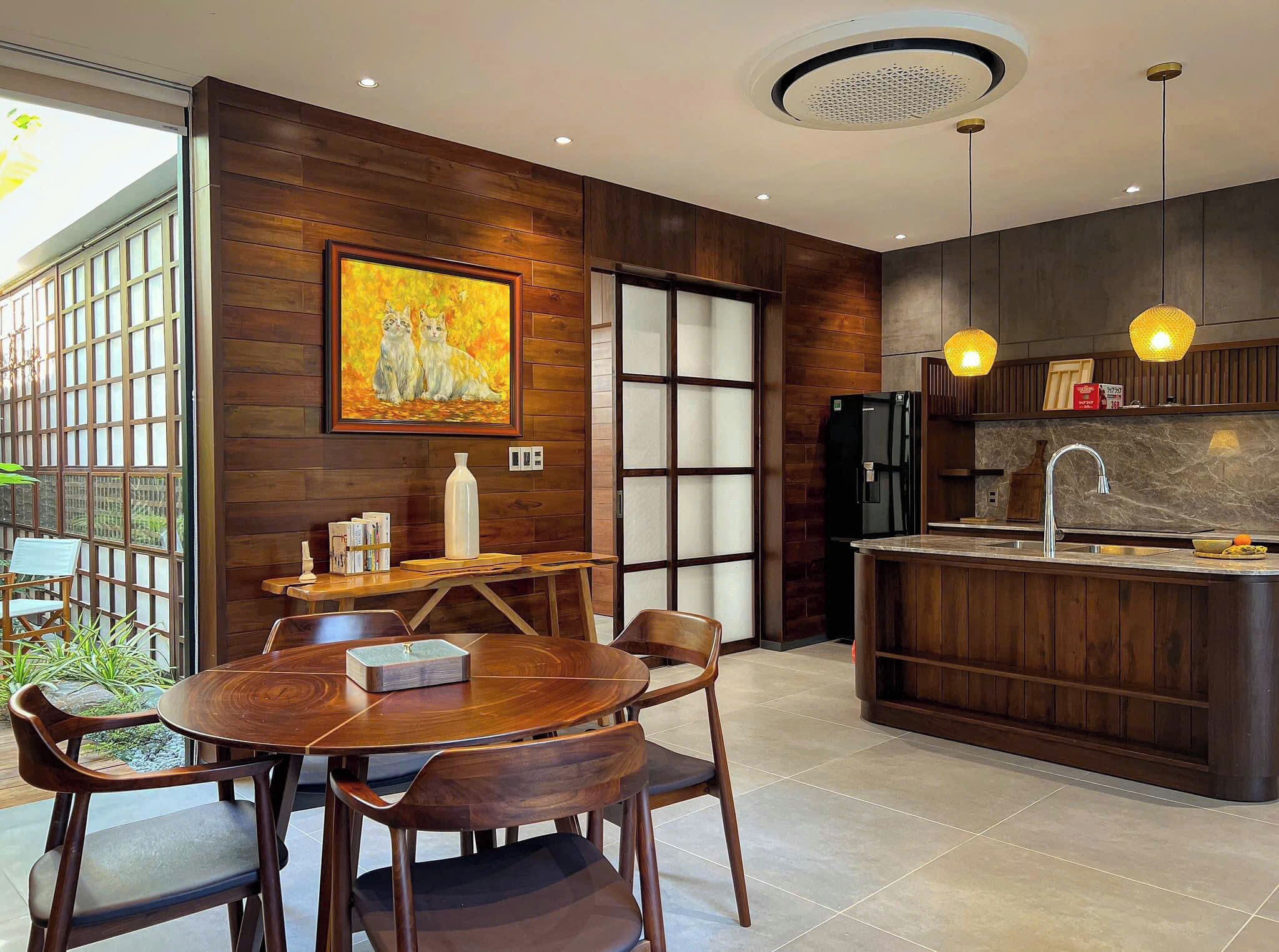 A modern kitchen with wooden cabinetry, a built-in island, and pendant lighting.