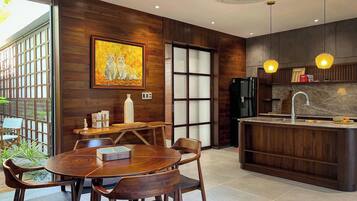 A modern kitchen with wooden cabinetry, a built-in island, and pendant lighting.