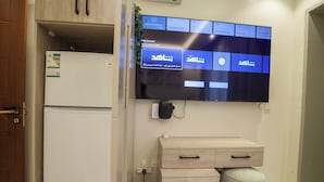 Une chambre d’hôtel moderne dotée d’un téléviseur à écran plat fixé au mur, qui affiche une interface de tableau de bord personnalisée.