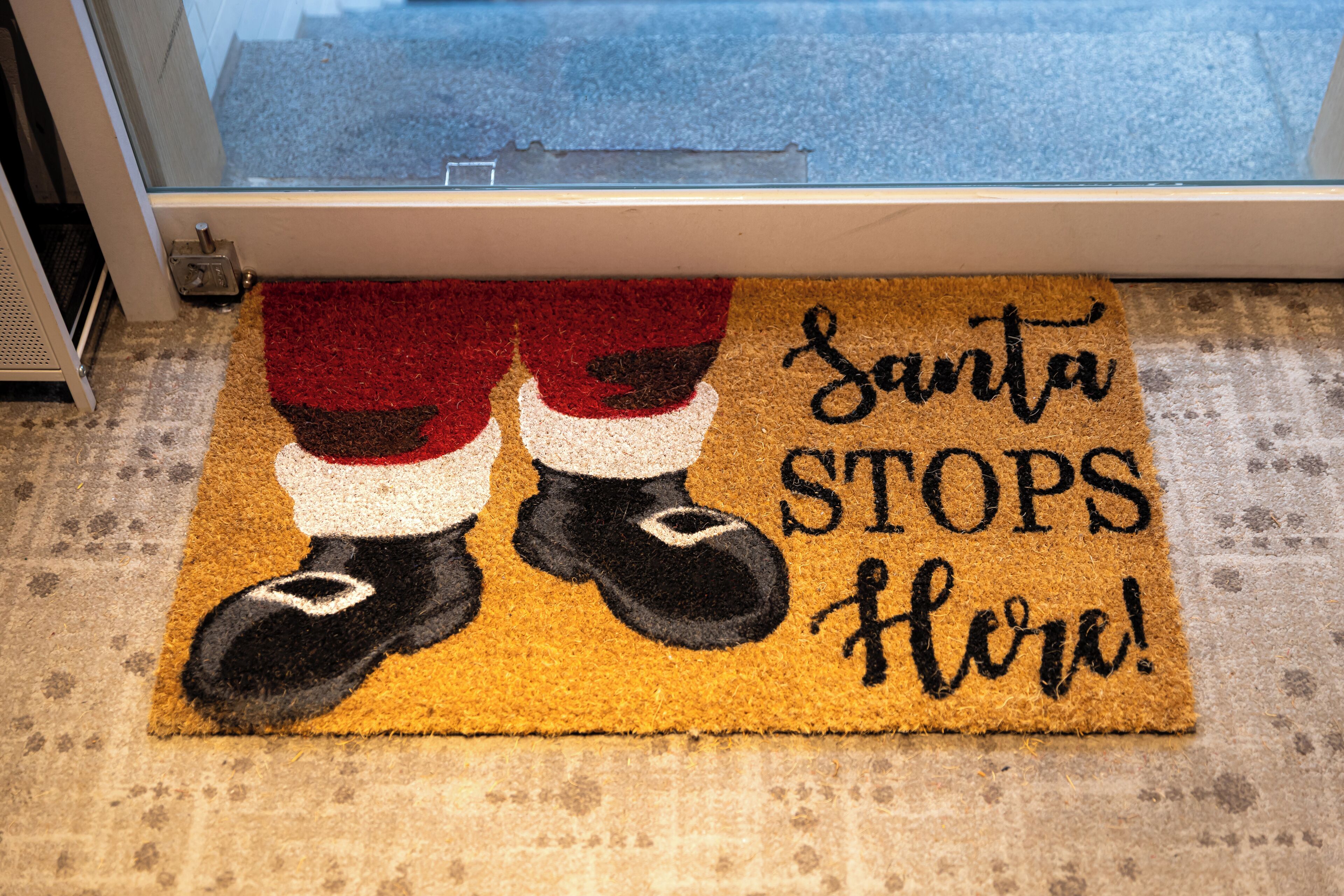 Eine Fußmatte mit Weihnachtsmann-Motiv und der Aufschrift 'Santa Stops Here!'