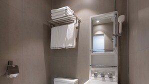 A modern bathroom with a toilet, a glass shower enclosure, and a sink with a mirror. - Bread Hill Hotel Jongno (Seoul)