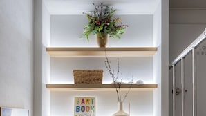 Ein Bücherregal mit verschiedenen Dekorationen und einem gerahmten Bild.