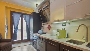 Una cocina moderna con electrodomésticos de acero inoxidable, horno empotrado y un lavamanos.