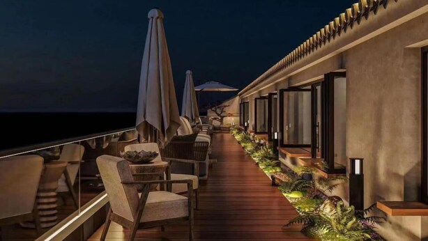 Terraza con asientos al aire libre, sombrillas y vista al mar.