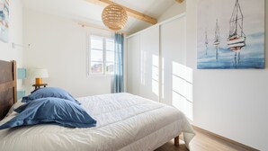 Une chambre à coucher avec un lit, une fenêtre, un tableau et un plafond en bois.