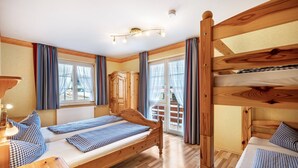 A wooden bunk bed room with a desk, a lamp, and a view of the outside. - Holiday Apartment 'Hofblick' with Shared Pool (Wolfach-Kirnbach)