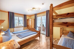 A wooden bunk bed room with a desk, a lamp, and a view of the outside. - Holiday Apartment 'Hofblick' with Shared Pool (Wolfach-Kirnbach)