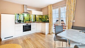 A compact kitchen with a modern stove, oven, and white cabinets. - Holiday Apartment 'Hofblick' with Shared Pool (Wolfach-Kirnbach)