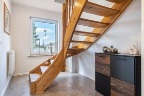 A wooden staircase leading to a loft bedroom with a view of a tree and a building outside. - Holiday Home 'Hedrich' with Private Terrace, Private Garden and Wi-Fi (Gülzow)