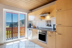 A kitchen with wooden cabinets, a stove, and a dishwasher.