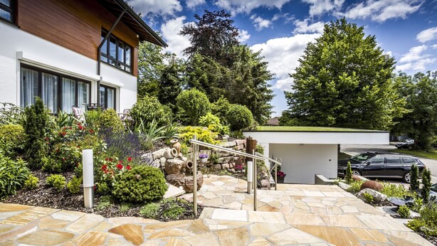 A modern house with a stone patio, a small garden, and a garage. - Apartment 'With 78 sqm' with Private Terrace and Wi-Fi (Höchenschwand)