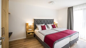 A hotel room with a bed, bedside tables, a wardrobe, and a window with curtains. - Apartment 'With 78 sqm' with Private Terrace and Wi-Fi (Höchenschwand)