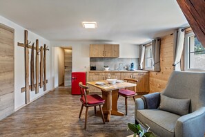 A compact living space with a dining area, kitchen, and seating area.