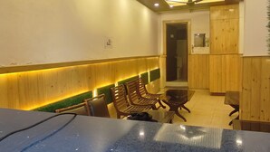 A modern interior with a blue countertop, wooden seating, and a ceiling with recessed lighting and a fan. - HOTEL CLOUD HEIGHT (Dharamshala)