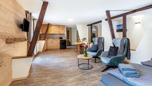 Un interior moderno con paredes de madera, cocina, comedor y zona de estar con vistas.