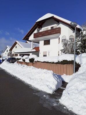 A two-story building with a snow-covered roof and a balcony. - Apartment 'Mayntz' Albjuwel' with Shared Terrace, Shared Garden and Wi-Fi (Meßstetten)