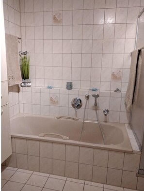 A bathroom with a bathtub, a shower, and a toilet. - Apartment 'Mayntz' Albjuwel' with Shared Terrace, Shared Garden and Wi-Fi (Meßstetten)