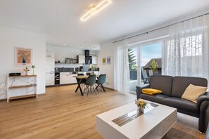 Una sala moderna con sofá, mesa de centro y zona de comedor.