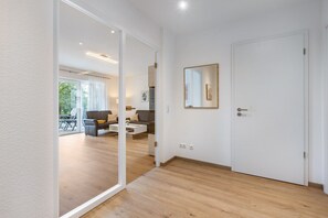 Una sala de estar moderna con un sofá, una mesa de centro y un espejo grande en la pared.