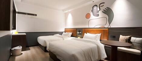 Una habitación de hotel moderna con dos camas, una mesita y un sofá.
