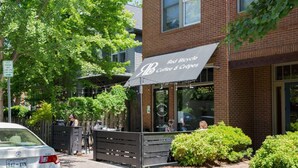 Ein Geschäft von Red Bicycle Coffee & Crepes mit Außenbestuhlung und einer Fassade aus Ziegelsteinen.