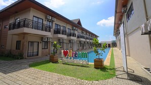 Un hotel con piscina, un cartel que dice “I love dream residences” y un césped bien cuidado.