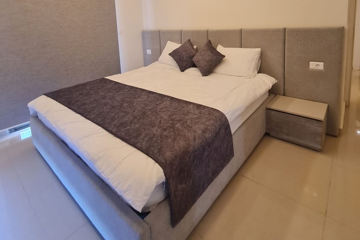 Una camera da letto moderna con un letto grande, un comodino e una testiera.