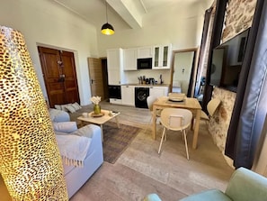 A modern living room with a sofa, coffee table, and dining area.