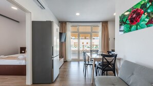 A compact hotel room with a kitchenette, a dining area, and a sofa. - Seaview Haven - Trendafili (Ishëm)