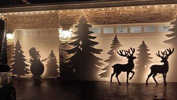Un garaje con fachada de piedra y un adorno navideño con silueta de árbol.