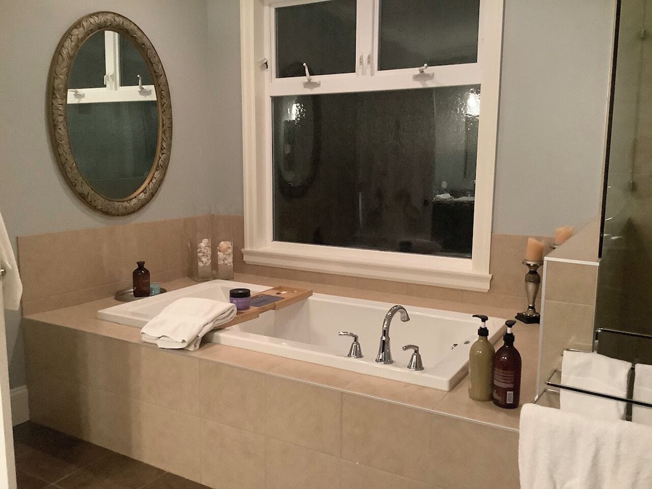 Une salle de bain avec une grande baignoire, un lavabo double et un miroir au-dessus du lavabo.