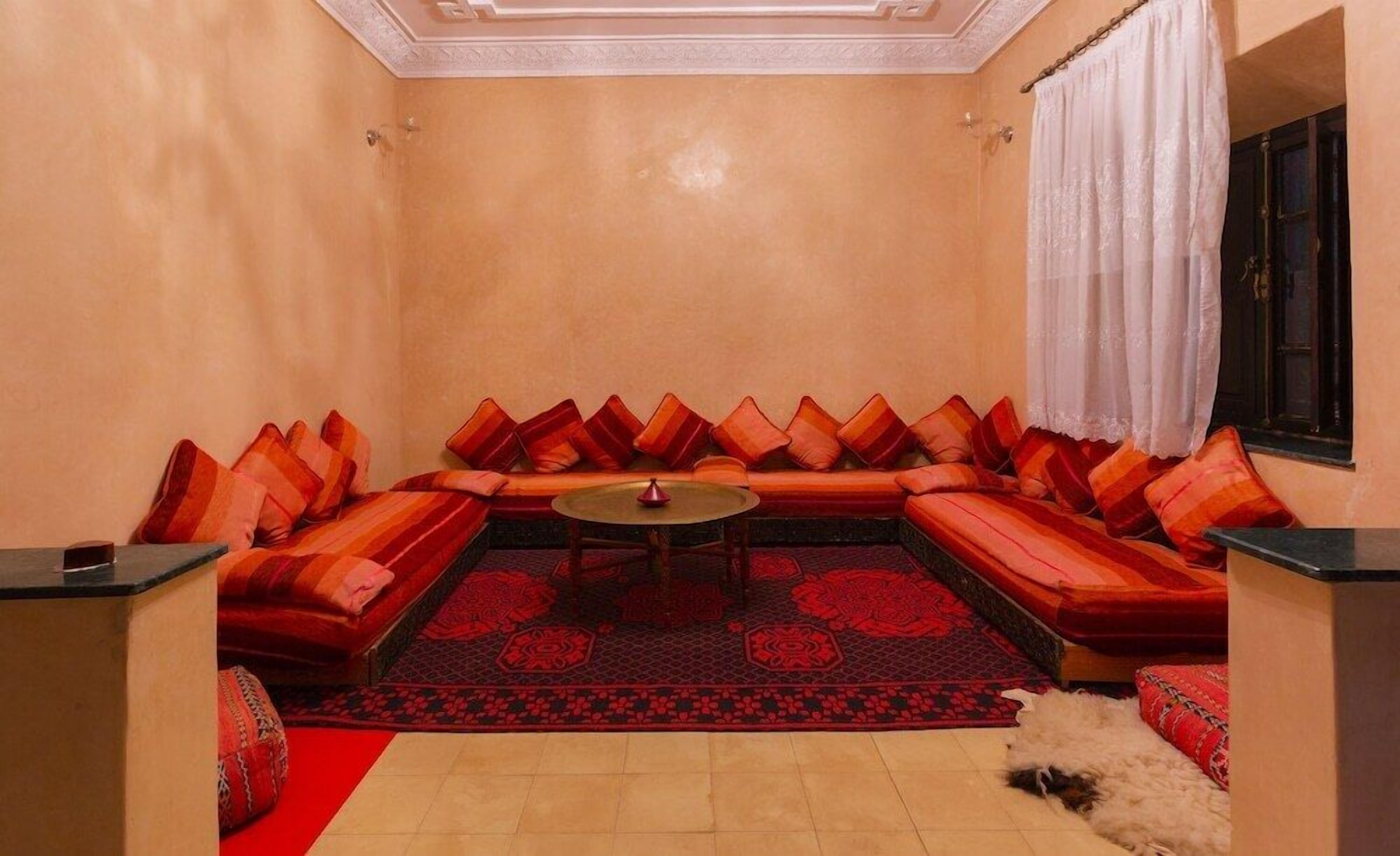 Ein gemütliches Zimmer mit einer Sofagarnitur, einem kleinen runden Tisch und einem gemusterten Teppich.
