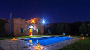 Une maison moderne dotée d’une piscine, d’un hall d’entrée bien éclairé et d’un espace salon extérieur.