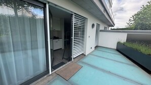 A modern building with a sliding glass door leading to a kitchen area. - Beautiful apartment in Rüschlikon Zurich (Rüschlikon)