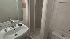 A bathroom with a white sink, mirror, toilet, and a glass-enclosed shower. - Ski studio at the foot of the slopes Valfréjus ski resort (Valfréjus)