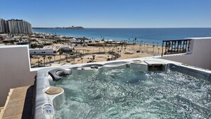 Un bain à remous avec vue sur la plage et l’océan.