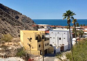 Un bâtiment situé sur la côte, doté d’un toit plat, d’un balcon et offrant une vue sur la mer.
