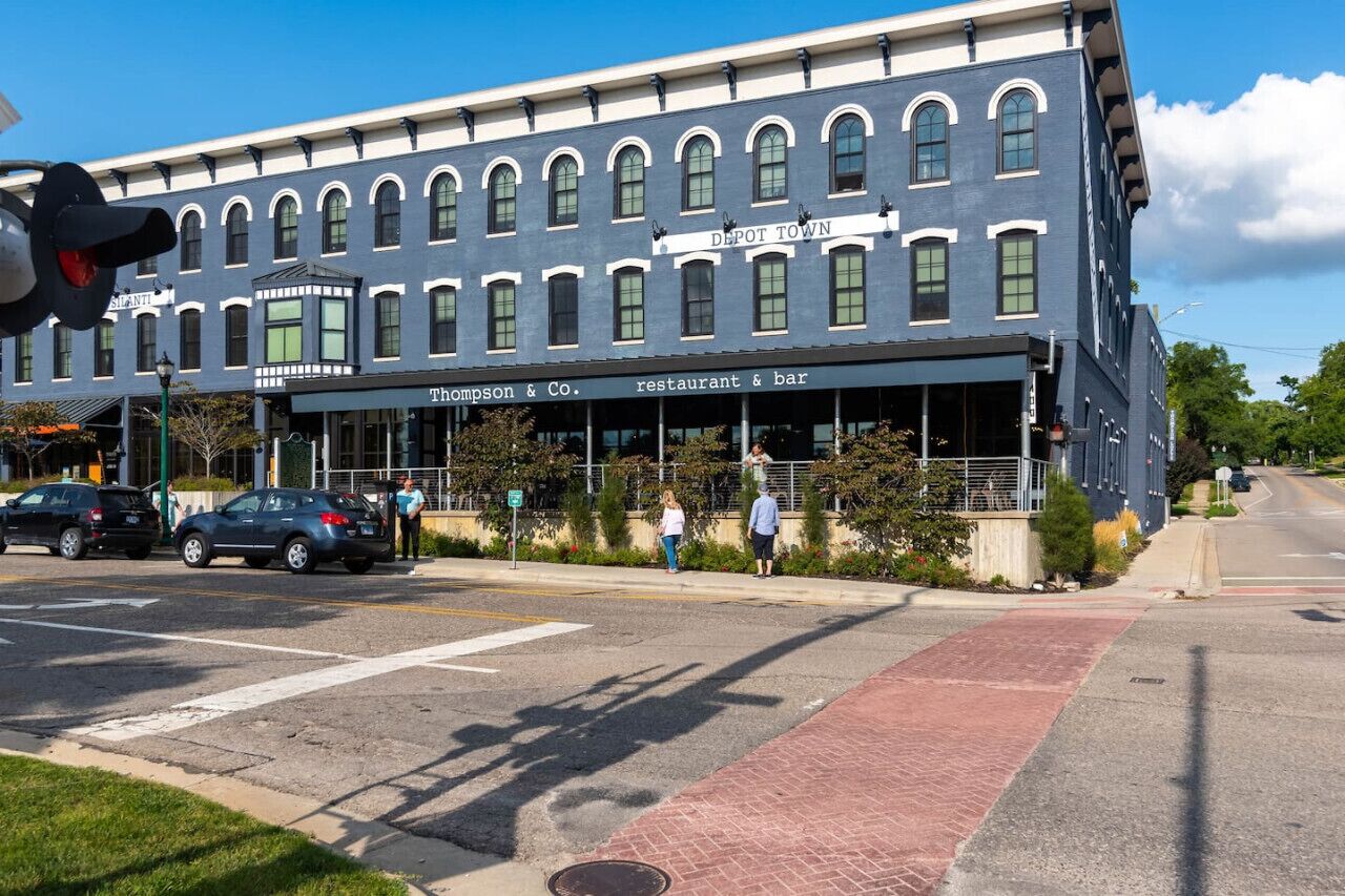 A two-story building with a sign reading 'Depot Town' and a restaurant named 'Thompson & Co.'