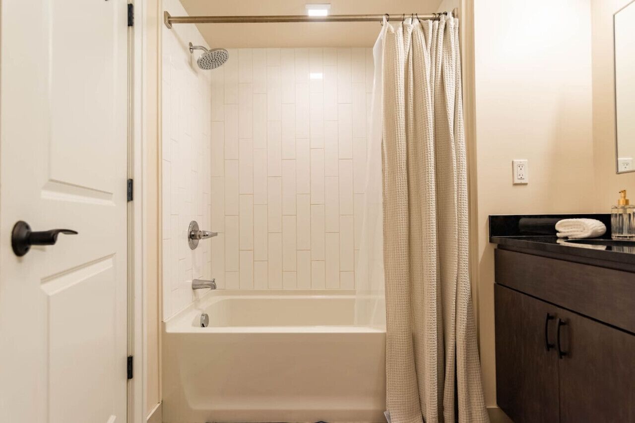 A bathroom with a shower, a bathtub, a toilet, and a vanity with a mirror.