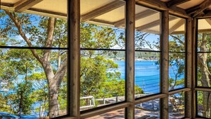 Une structure en bois offrant une vue sur un plan d’eau et des arbres.