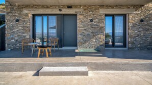 A modern building with stone walls and large sliding glass doors labeled "SUITE 2".