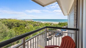 Un balcon avec vue sur la plage et l’océan.