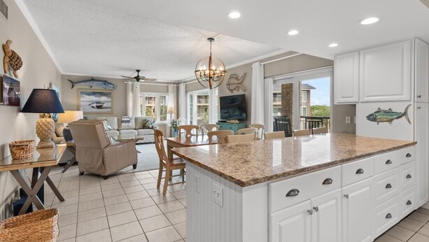 A spacious kitchen with a large island, white cabinetry, and a view to the outside. - 3rd Flr, 3 Bdrm Oceanview Condo Beach Oasis (Pawleys Island)